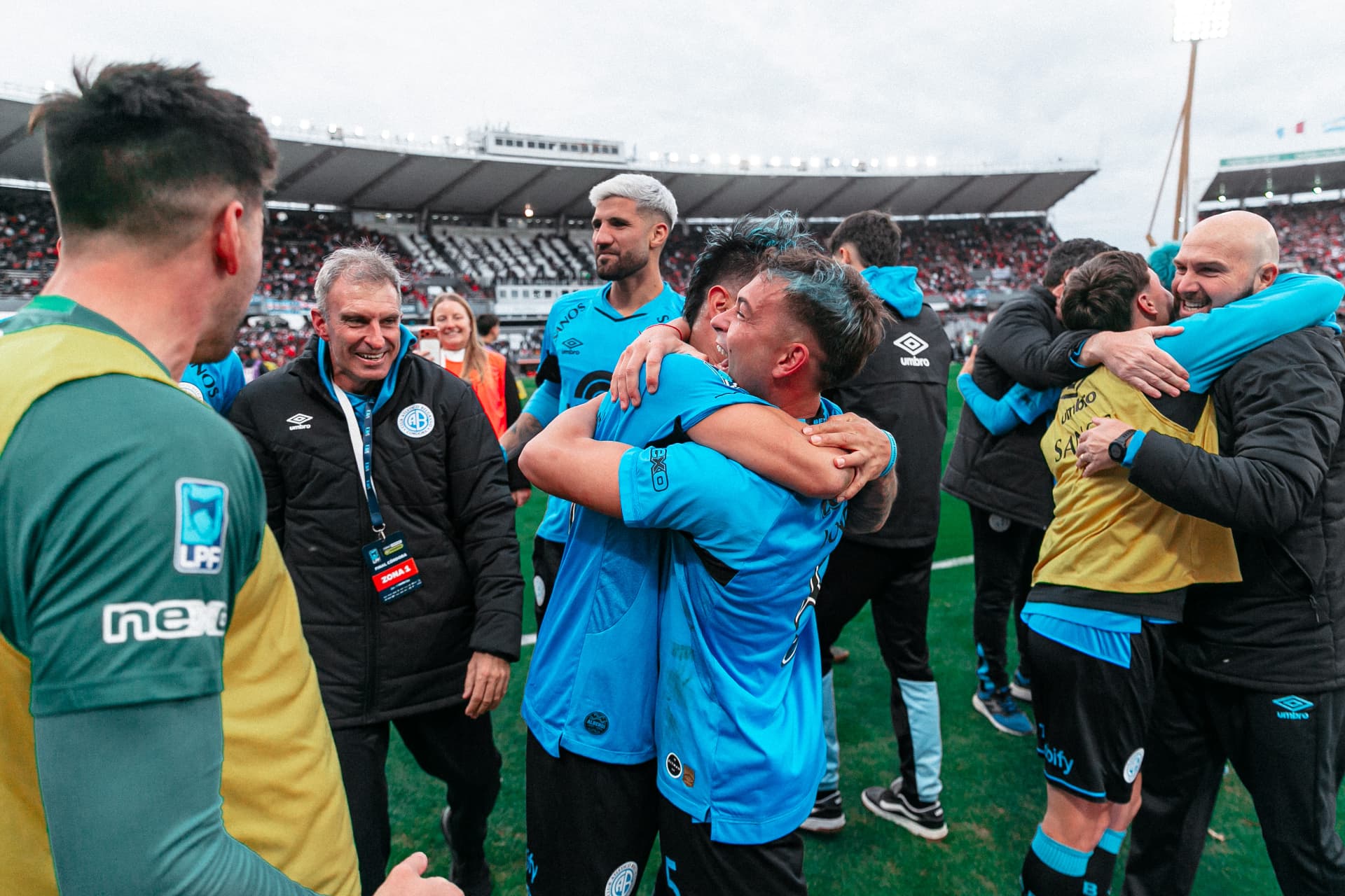 Abrazo apretado entre jugadores de Belgrano en el campo