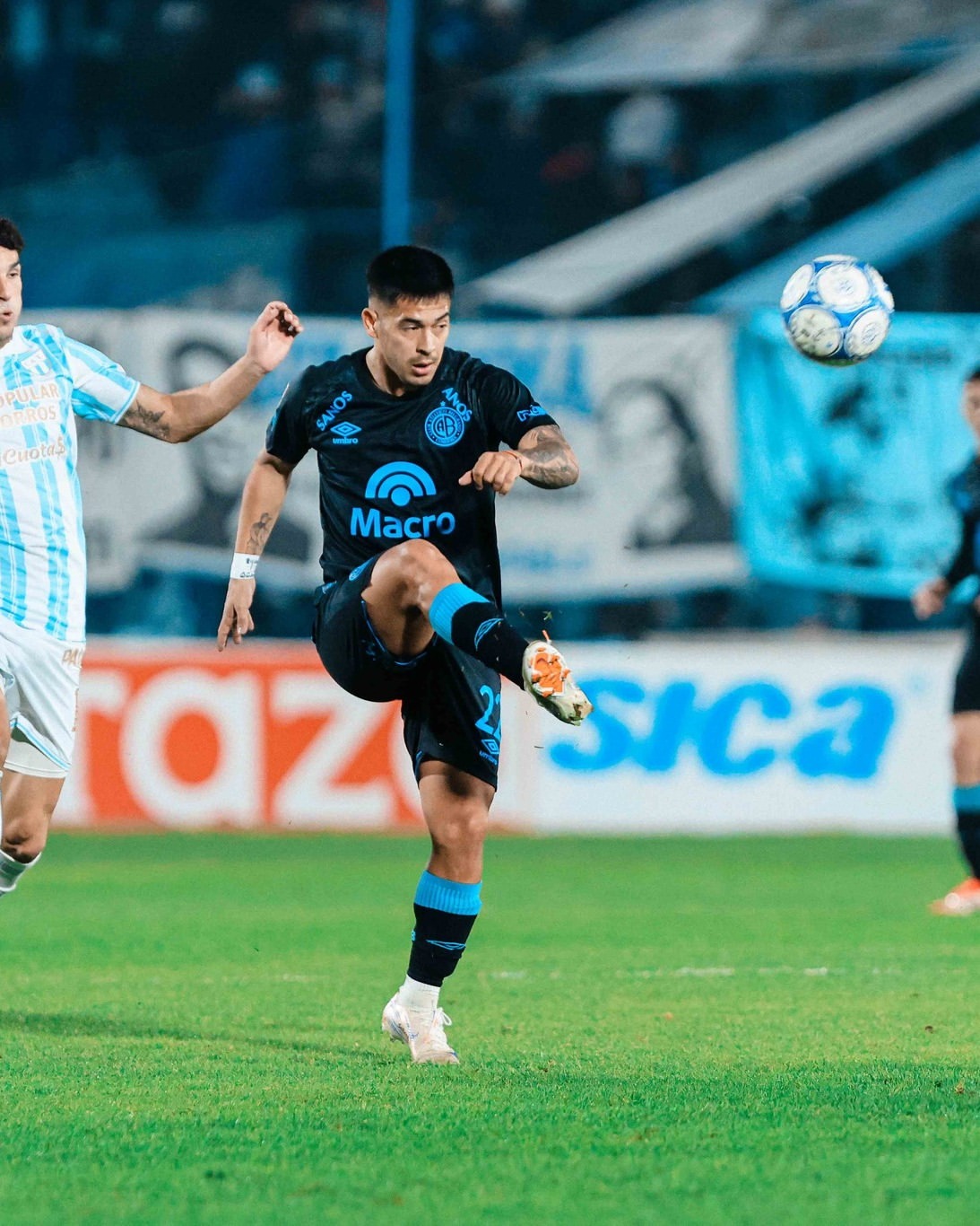 Mediocampista de Belgrano ejecutando un pase largo